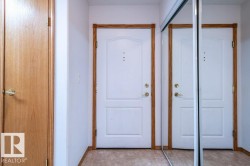 White paneled doors with wood trim, brass hardware, and a full-length mirrored closet door - 