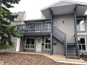 Two-story exterior with multi-pane windows and a gray siding finish - #68 1503 Mill Woods Rd E Nw, Edmonton, AB 