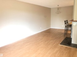 Recessed lighting, wood-finish flooring, neutral wall tones, breakfast bar, and pendant lighting - 
