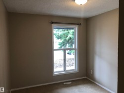 Single-pane window with white trim, wall-mounted light fixture, and light-colored walls - 