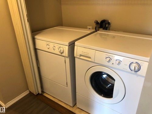 Dedicated laundry area with a front-loading washing machine and a separate dryer - #68 1503 Mill Woods Rd E Nw, Edmonton, AB 