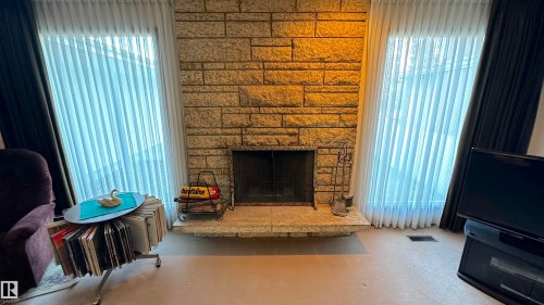 Tindlestone facade wood burning fireplace in the living room. - 4128 110 Street Nw, Edmonton, AB 