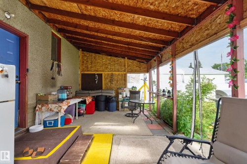 Covered outdoor patio with exposed wood beam ceiling and concrete flooring - 12309 80 Street Nw, Edmonton, AB 