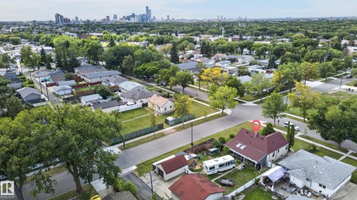 Residential property with a red-shingled roof and light-colored siding, situated on a corner lot - 12309 80 Street Nw, Edmonton, AB 