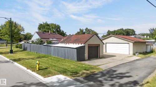 Two separate detached garages with pitched roofs, concrete driveways, and a private perimeter fence - 12309 80 Street Nw, Edmonton, AB 