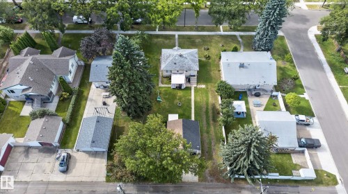 Two-story residence with a front porch, expansive lawn, mature trees, and a detached single-car garage - 12345 79 Street Nw, Edmonton, AB 