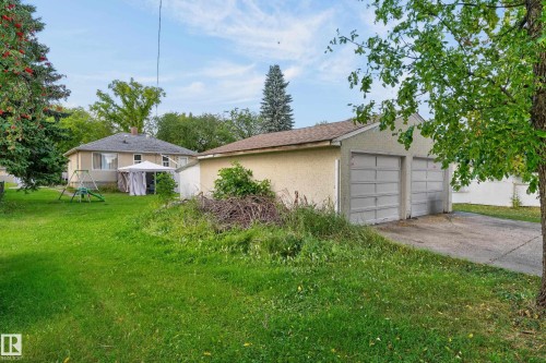 Detached two-car garage with panel doors, shingle roofing, and a concrete driveway - 12345 79 Street Nw, Edmonton, AB 