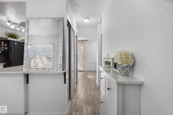 Wood-finish flooring throughout, white walls, and built-in hallway storage - 