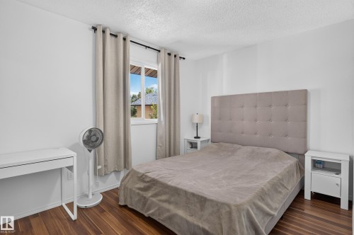 Wood-finish flooring, white walls, and a window with natural light - 130 Woodstock Nw, Edmonton, AB 