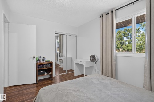 Wood-finish flooring, white walls, and a large window with exterior scenery - 130 Woodstock Nw, Edmonton, AB 