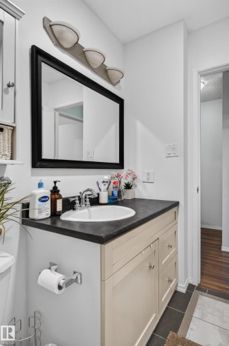 Vanity with dark countertop and integrated sink - 130 Woodstock Nw, Edmonton, AB 