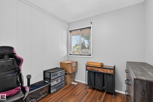 Wood-finish flooring with light-colored walls and a window with blinds - 130 Woodstock Nw, Edmonton, AB 