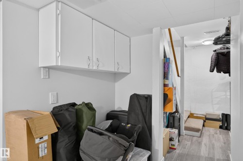Built-in white cabinetry, light gray walls, and wood-finish flooring - 130 Woodstock Nw, Edmonton, AB 
