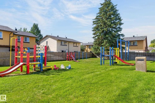 Expansive green space featuring multiple play structures with slides, a balance beam, and swings - 130 Woodstock Nw, Edmonton, AB 