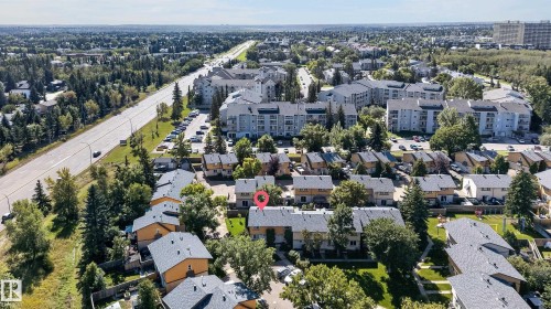 Residential neighborhood featuring townhomes and multi-story buildings, surrounded by mature trees and green spaces - 130 Woodstock Nw, Edmonton, AB 