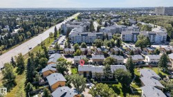 Residential neighborhood featuring townhomes and multi-story buildings, surrounded by mature trees and green spaces - 