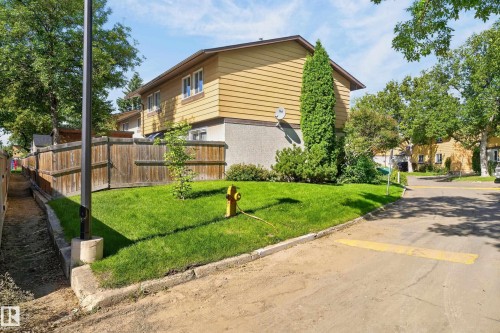 Yellow-sided exterior with white window trim - 130 Woodstock Nw, Edmonton, AB 