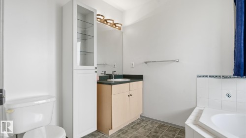Vanity with a solid surface countertop, an integrated sink, and an overhead light fixture - 2117 36 Avenue Nw, Edmonton, AB 