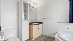 Vanity with a solid surface countertop, an integrated sink, and an overhead light fixture - 