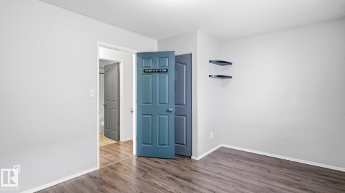 Wood-finish flooring throughout, light neutral wall paint, and white trim - 2117 36 Avenue Nw, Edmonton, AB 