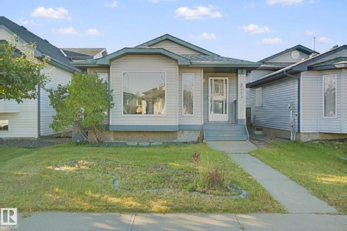 Siding exterior with a covered entry, an expansive front window, and a concrete walkway - 2117 36 Avenue Nw, Edmonton, AB 