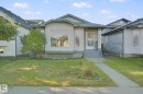 Siding exterior with a covered entry, an expansive front window, and a concrete walkway - 2117 36 Avenue Nw, Edmonton, AB 