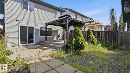 Rear exterior with horizontal siding, sliding glass door, multi-level wood deck, and a detached gazebo - 2117 36 Avenue Nw, Edmonton, AB 