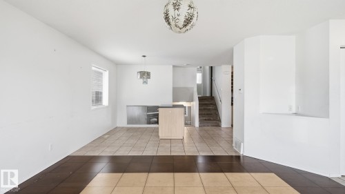 Wood-finish and tile flooring, light-toned walls, and a built-in kitchen island - 2117 36 Avenue Nw, Edmonton, AB 