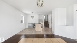 Wood-finish and tile flooring, light-toned walls, and a built-in kitchen island - 