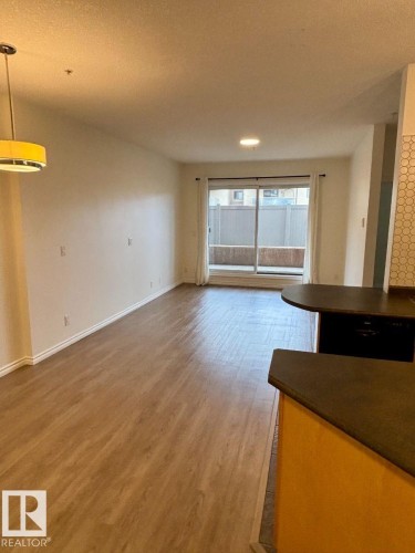 Wood-finish flooring, sliding glass door, recessed lighting, pendant lighting, built-in breakfast bar with countertop - #103 10346 117 St Nw, Edmonton, AB 