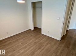 Wood-finish flooring throughout, neutral wall tones, and overhead lighting - 