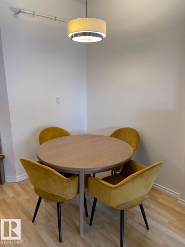 Wood-finish flooring with crisp white baseboards and neutral wall tones - #103 10346 117 St Nw, Edmonton, AB 