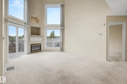 Vaulted ceilings with multiple windows, recessed fireplace with mantel, sliding glass door to exterior, and wall-to-wall carpeting - 