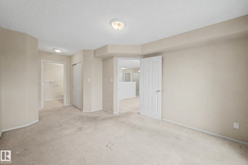 Neutral-toned walls and ceiling, carpeted flooring, and traditional interior doors - #505 7839 96 St Nw, Edmonton, AB 
