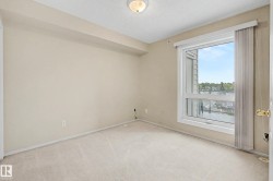 Wall-to-wall carpeting, neutral wall color, and a large window with vertical blinds - 