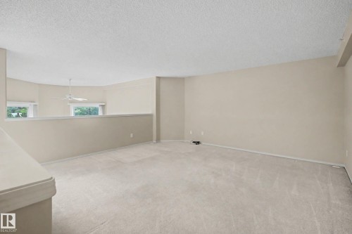 Carpeted flooring throughout, neutral painted walls, and textured ceilings - #505 7839 96 St Nw, Edmonton, AB 