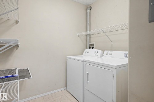 Laundry area featuring tiled flooring, wire shelving, and appliance hookups - #505 7839 96 St Nw, Edmonton, AB 