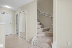 Carpeted staircase, mirrored closet doors, and light-toned flooring - 
