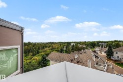 Extensive tree coverage, residential rooftops, and clear sky conditions - 