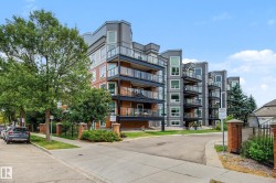 Modern multi-story building featuring extensive balconies with glass railings - 