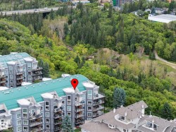 Multi-story building featuring balconies and a green roof - 