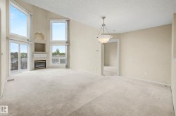 Vaulted ceiling living space featuring an electric fireplace with mantel, built-in wall niches, expansive windows, and a glass sliding door - 