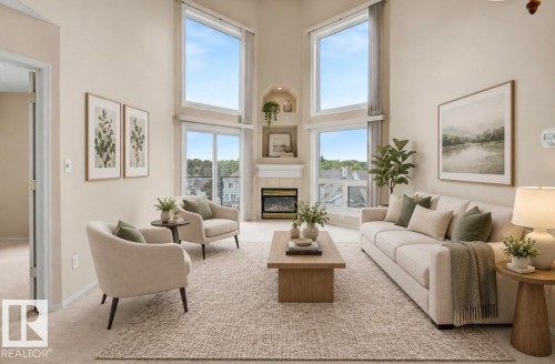 Vaulted ceiling, two-story windows, built-in electric fireplace with mantle, sliding glass door, and neutral-toned carpeting - #505 7839 96 St Nw, Edmonton, AB 