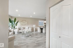 Recessed lighting illuminates the living space with light-tone walls and wood-finish flooring - 