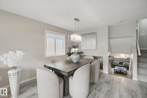Recessed lighting, wood-finish flooring, and a contemporary linear chandelier illuminate this dining area - 13912 156 Avenue Nw, Edmonton, AB 