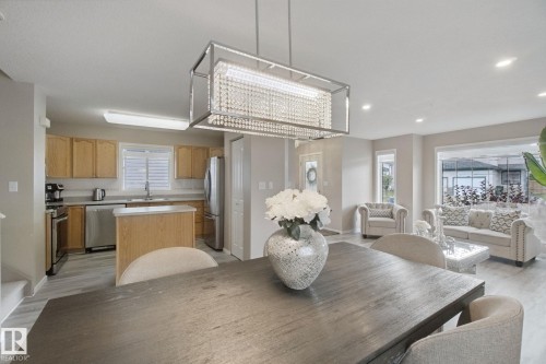 Recessed lighting, wood-finish flooring, stainless steel appliances, kitchen island, and a crystal chandelier - 13912 156 Avenue Nw, Edmonton, AB 