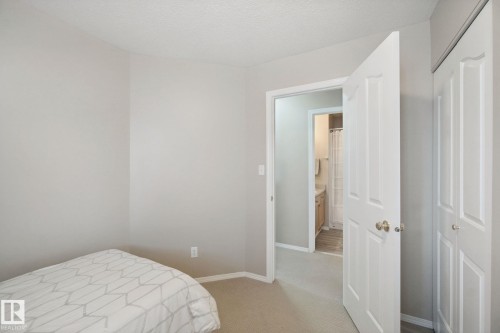 Neutral tone wall paint, carpet flooring, white paneled doors, and a built-in closet - 13912 156 Avenue Nw, Edmonton, AB 