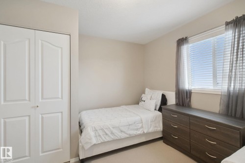 Neutral wall tones, window with horizontal blinds, and a bi-fold closet door with panel detailing - 13912 156 Avenue Nw, Edmonton, AB 