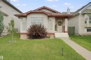 Siding exterior with contrasting trim, covered front porch, and front entry with sidelight windows - 13912 156 Avenue Nw, Edmonton, AB 