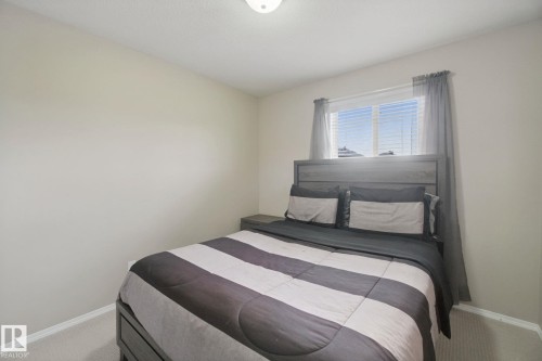 Neutral wall paint, ceiling-mounted light fixture, window with blinds, and light-toned carpeting - 13912 156 Avenue Nw, Edmonton, AB 